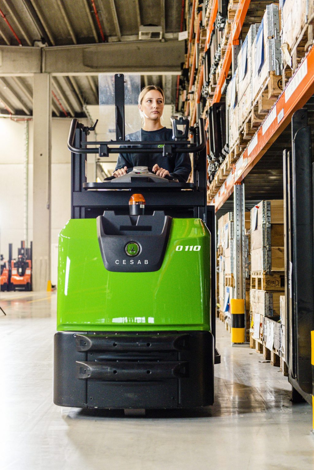 A forklift driver operating an order picker in a warehouse
